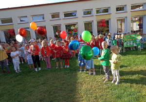 Przedstawiciele grup trzymają w rękach balony napełnione helem.