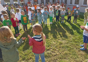 Dzieci stoją w kole i wykonują ruchy zgodne z treścią piosenki.