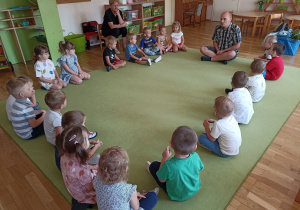 Dzieci siedzą na dywanie i słuchają opowieści o patyczakach rogatych, straszykach i jeżach.