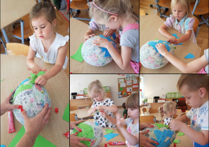 Dzieci ozdabiają globus kolorowym papierem