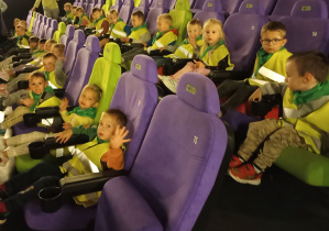 Dzieci po zajęciu miejsc w sali kinowej czekają na seans.