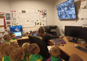 Dzieci obserwują na monitorze różne pomieszczenia znajdujące się w kinie.