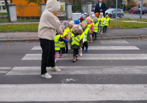 Dzieci prawidłowo przechodzą na drugą stronę ulicy.