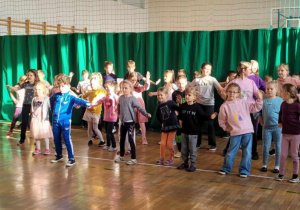 Przedszkolaki i uczniowie tańczą do piosenki.