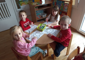 Dzieci przy trzecim stoliku kolorują okolicznościowe obrazki.