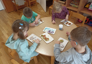 Dzieci przy szóstym stoliku dekorują upieczone pierniczki.