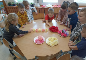 Dzieci układają rytmy z kwiatów.