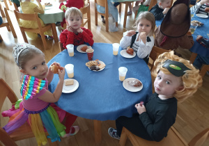 Gabrysia, Igor, Ania i Bartosz jedzą słodki poczęstunek.
