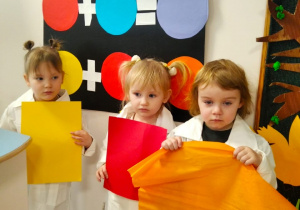 Dziewczynki pokazują kolorowe kartki a dzieci nazywają powstały kolor