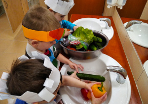 Chłopcy myją warzywa