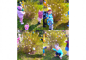 Dzieci ozdabiają drzewko pisankami.