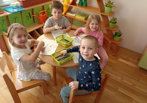 Dzieci przy szóstym stoliku kolorują obrazki o tematyce wielkanocnej.