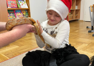 Przedszkolaki trzymają węża zbożowego.