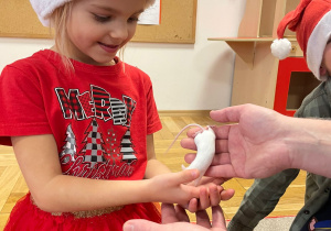 Przedszkolaki trzymają mysz laboratoryjną.