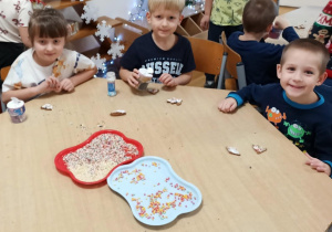 Dzieci dekorują upieczone pierniczki.