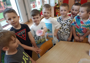 Przedszkolaki pokazują, że kartka papieru pozostała sucha.