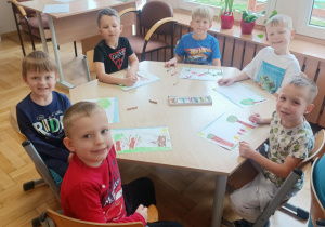 Dzieci przy trzecim stoliku wykonują pracę plastyczną.