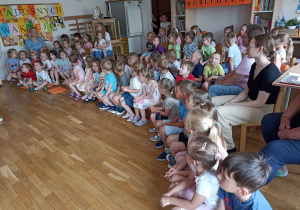 Dzieci oglądają występujące koleżanki i kolegów z grupy pomarańczowej.