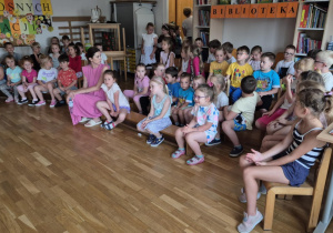 Dzieci oglądają występujące koleżanki i kolegów z grupy pomarańczowej.