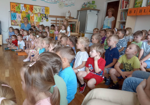 Dzieci oglądają występujące koleżanki i kolegów z grupy pomarańczowej.