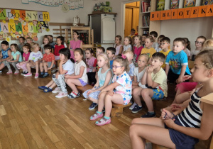 Dzieci oglądają występujące koleżanki i kolegów z grupy pomarańczowej.