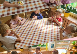 Dzieci jedzą przygotowane babeczki.