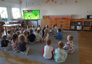 Przedszkolaki oglądają film edukacyjny o kropce.