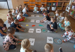 Trzecia grupa dzieci bierze udział w zabawie matematycznej „Ile kropek?”.