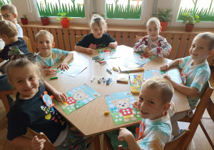 Przedszkolaki przy czwartym stoliku wykonują pracę plastyczną „Miś z kropek”.