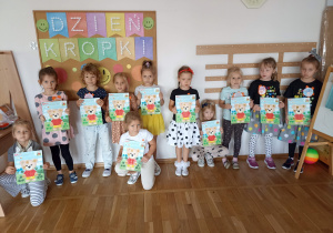 Dziewczynki prezentują wykonane prace plastyczne.