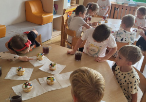 Dzieci oglądają udekorowane babeczki.