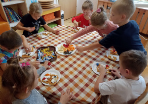 Dzieci przy drugim stoliku przygotowują gofry.