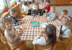 Słodki poczętunek przedszklaków przy trzecim stoliku.