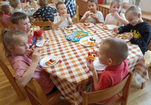Słodki poczętunek dzieci przy czwartym stoliku.