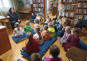 Pani bibliotekarka mówi dzieciom jak należy dbać o książki.