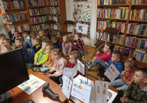 Przedszkolaki słuchają opowieści pani bibliotekarki.