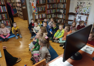 Dzieci słuchają opowieści pani bibliotekarki.