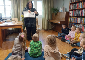 Pani Aneta pokazuje dzieciom książkę pt. „Impro Frycek”.