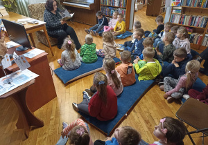 Przedszkolaki słuchają treści książki o Fryderyku Chopinie.