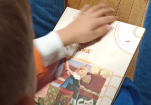 Dzieci oglądają książkę o Fryderyku Chopinie.