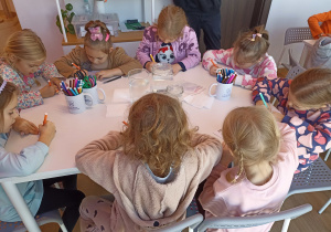 Dzieci tworzą i eksperymentują przy stolikach.