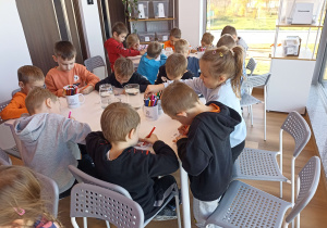 Dzieci tworzą i eksperymentują przy stolikach.