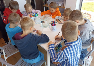 Dzieci tworzą i eksperymentują przy stolikach.