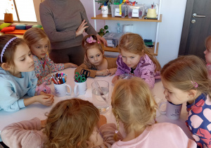 Dzieci tworzą i eksperymentują przy stolikach.