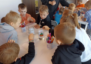 Dzieci tworzą i eksperymentują przy stolikach.