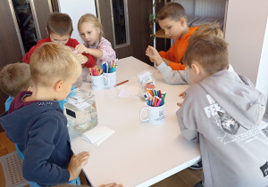 Dzieci tworzą i eksperymentują przy stolikach.