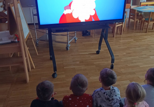 Przedszkolaki oglądają mikołajkowy film edukacyjny.