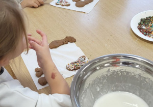 Przedszkolaki dekorują upieczone pierniczki.