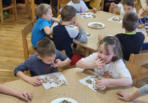 Dzieci jedzą udekorowane pierniczki.