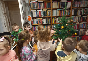 Przedszkolaki ubierają choinki.